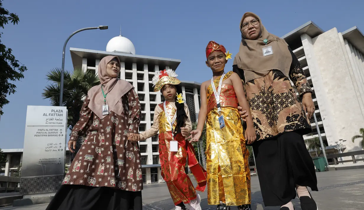 Para pembawa bunga dengan pakaian adat terlihat di Masjid Istiqlal menjelang kedatangan Paus Fransiskus untuk pertemuan antaragama dengan para pemimpin agama, di Jakarta, Kamis (5/9/2024). (Yasuyoshi CHIBA / POOL / AFP)