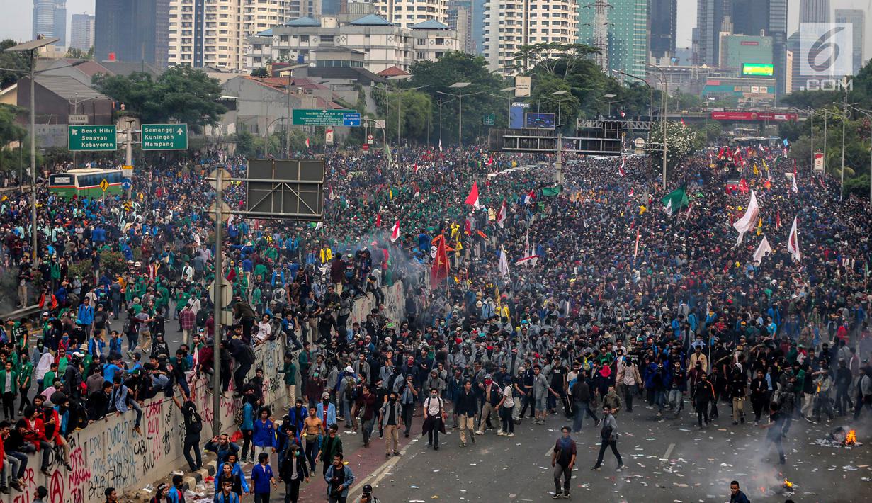 Mahasiswa berlarian saat polisi menembakkan gas air mata dalam demonstrasi menolak pengesahan RUU KUHP dan revisi UU KPK di depan Gedung DPR, Jakarta, Selasa (24/9/2019). Polisi menghalau mahasiswa yang berusaha masuk ke area Gedung DPR. (Liputan6.com/Faizal Fanani)