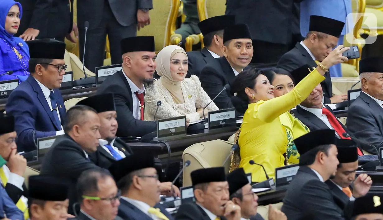 Penyanyi serta musisi, Ahmad Dhani dan Mulan Jameela saat rapat paripurna pelantikan anggota DPR Republik Indonesia terpilih periode 2024-2029 di Gedung Nusantara, Kompleks Parlemen, Senayan, Jakarta, Selasa (1/10/2024). Ahmad Dhani dan Mulan Jameela terpilih dari Partai Gerindra. Ahmad Dhani dari daerah pemilihan Jawa Timur I dengan perolehan suara sebanyak 134.227. Mulan Jameela dari daerah pemilihan Jawa Barat XI dengan perolehan suara sebanyak 83.526. (Liputan6.com/Angga Yuniar)