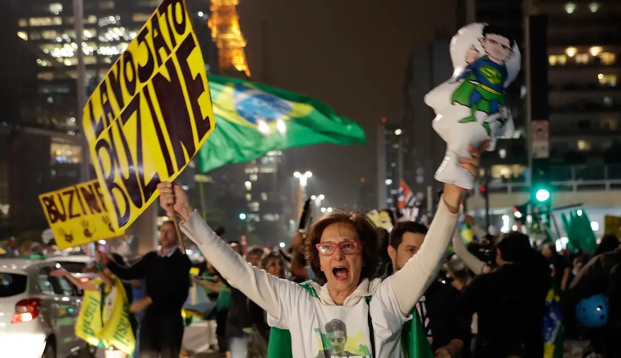 Demonstran merayakan keputusan Hakim Sergio Moro menjatuhkan hukuman ke mantan Presiden Brasil Luiz Inacio Lula da Silva, di Sao Paulo, Brasil, (12/7). Silva divonis bersalah atas tuduhan korupsi. (AP Photo/Andre Penner)