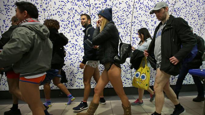 Sejumlah penumpang tanpa mengenakan celana bersiap menaiki kereta selama No Pants Subway Ride ke-18 di London Underground di London, Inggris (13/1). Peringatan ini dilaksanakan setiap tahunnya bermula dari Kota New York, AS. (AFP Photo/Daniel Leal-olivas)