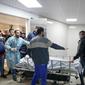 Para jurnalis dan petugas medis tampak membawa jenazah Shiren Abu Akleh, jurnalis Al Jazeera yang tewas tertambak oleh pasukan Israel, ke dalam kamar mayat di salah satu rumah sakit di Jenin, Tepi Barat, pada 11 Maret 2022. (Foto: AP/Majdi Mohammed)