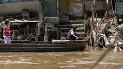 Jauhnya jarak jembatan penyebrangan membuat sejumlah warga lebih memilih menggunakan jasa perahu eretan di sungai Ciliwung, Kamis (24/4/14). (Liputan6.com/Faizal Fanani)