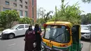 <p>Orang-orang berbicara dengan pengemudi bajaj Mahender Kumar&nbsp; saat ia duduk di kendaraannya dengan 'taman' di atapnya, di New Delhi, India pada 2 Mei 2022. Bajaj kuning dan hijau ada di mana-mana di jalan-jalan New Delhi tetapi kendaraan Mahendra Kumar sangat menonjol -- ia memiliki taman di atapnya bertujuan untuk menjaga penumpang tetap sejuk selama musim panas yang menyengat. (Money SHARMA / AFP)</p>