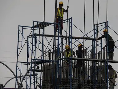 Pekerja memasang tiang penyangga untuk proyek pembangunan jalan tol Cimanggis-Cibitung (Cimaci) di Jalan Alternatif Cibubur, Jatikarya, Jatisampurna, Kota Bekasi, Jumat (23/11). (Merdeka.com/Imam Buhori)