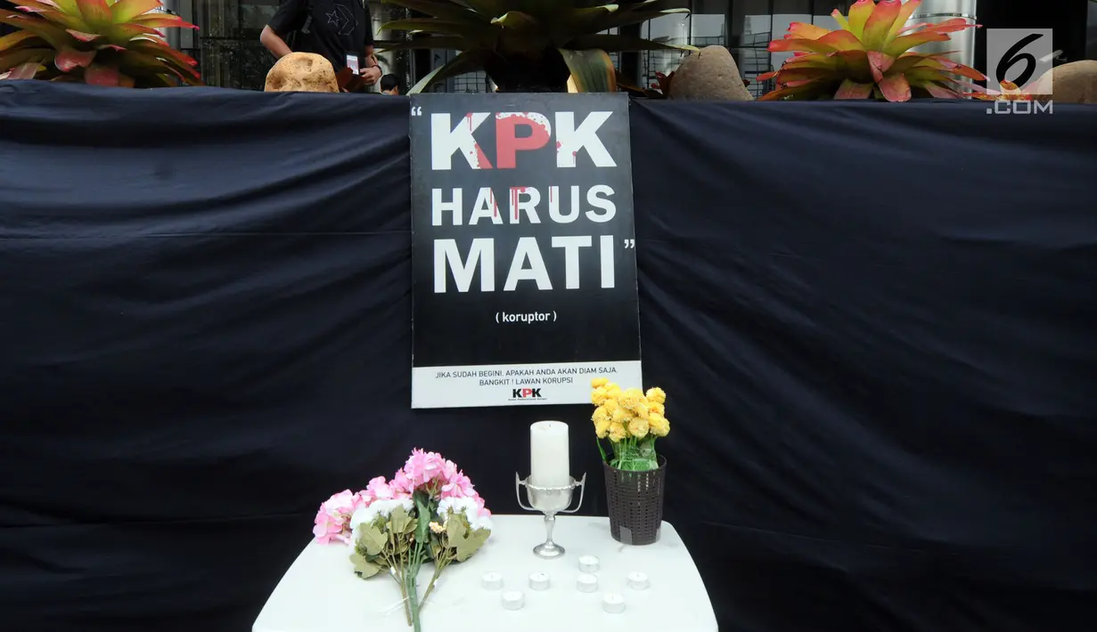 Bunga terlihat dekat kain hitam besar yang menutupi logo KPK di Gedung Merah Putih, Jakarta, Senin (9/9/2019). Keberadaan kain hitam dan karangan bunga ini merupakan bentuk protes atas revisi Undang-undang KPK yang dinilai dapat melemahkan KPK. (merdeka.com/Dwi Narwoko)