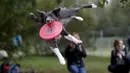 Aksi anjing menangkap frisbee dalam kompetisi frisbee anjing di Moskow, Minggu (13/9). Anjing dan pemiliknya ambil bagian dalam berbagai kategori jarak dan tes akurasi pada kompetisi untuk menilai keterampilan frisbee mereka. (REUTERS/Sergei Karpukhi)