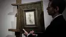 Seorang anggota Rumah Lelang Tajan memperlihatkan gambar sketsa karya Leonardo da Vinci sebelum dilelang di Paris, Prancis (13/12). Karya tersebut bernilai sekitar 16 juta USD. (AFP/Philippe Lopez)