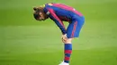 Penyerang Barcelona, Antoine Griezmann, tertunduk lesu usai ditaklukkan Granada pada laga Liga Spanyol di Stadion Camp Nou, Jumat (30/4/2021). Barcelona takluk dengan skor 1-2. (AFP/Lluis Gene)