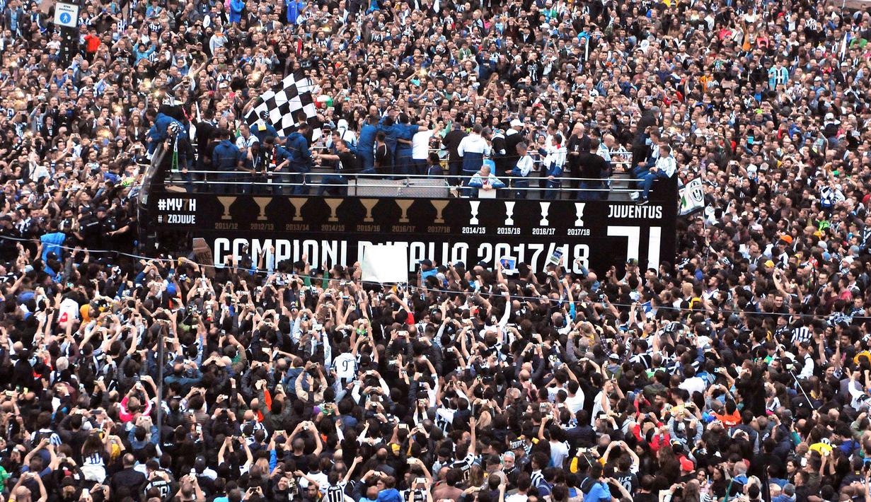 Bus pemain Juventus melintasi kerumunan fans saat parade keberhasilan meraih trofi Serie A di Turin, Italia, (19/5/2018). Juventus raih gelar Seri A tujuh kali secara beruntun. (Alessandro Di Marco/ANSA via AP)