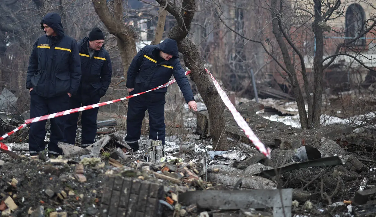 Untuk diketahui, invasi Rusia ke Ukraina telah masuk tahun keempat sejak serangan skala penuh dimulai pada 24 Februari 2022. Tampak dalam foto, tim penyelamat Ukraina memeriksa sisa-sisa senjata udara di lokasi sebuah rumah yang rusak parah setelah serangan udara di Sofiivska Borshchagivka, wilayah Kyiv pada Minggu 22 Februari 2026. (Henry NICHOLLS/AFP)