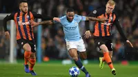 Gelandang Manchester City, Raheem Sterling berusaha melewati dua pemain Shakhtar Donetsk selama pertandingan grup F Liga Champions di stadion Etihad, Inggris (7/11). City menang 6-0 atas Shakhtar Donetsk. (AFP Photo/Oli Scarff)