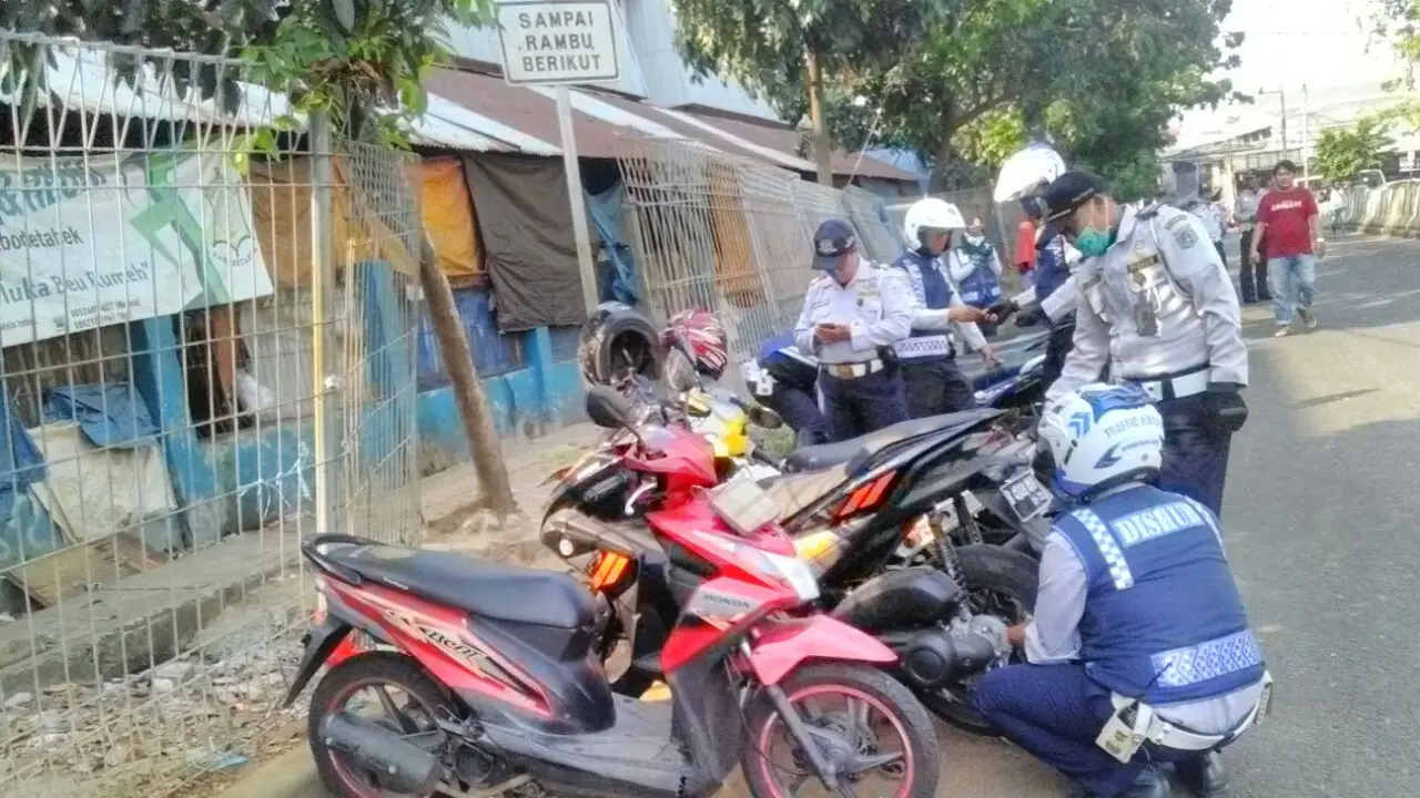 petugas gemboskan ban motor yang parkir sembarangan