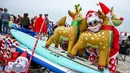 Seorang pengunjung berkostum Sinterklas berpose dalam acara Surfing Santa yang berlangsung di Pantai Cocoa, Florida, Amerika Serikat, Selasa (24/12/2024) waktu setempat. (AFP/Giorgio Viera)
