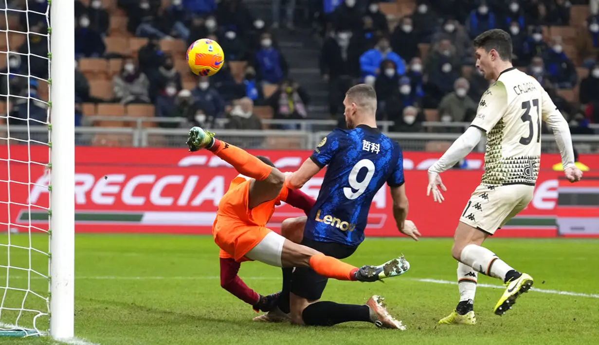 Pemain Inter Milan Edin Dzeko (kanan) bersaing memperebutkan bola dengan kiper Venezia Luca Lezzerini pada pertandingan sepak bola Liga Italia di Stadion San Siro, Milan, Italia, 22 Januari 2022. Inter Milan menang 2-1. (AP Photo/Luca Bruno)