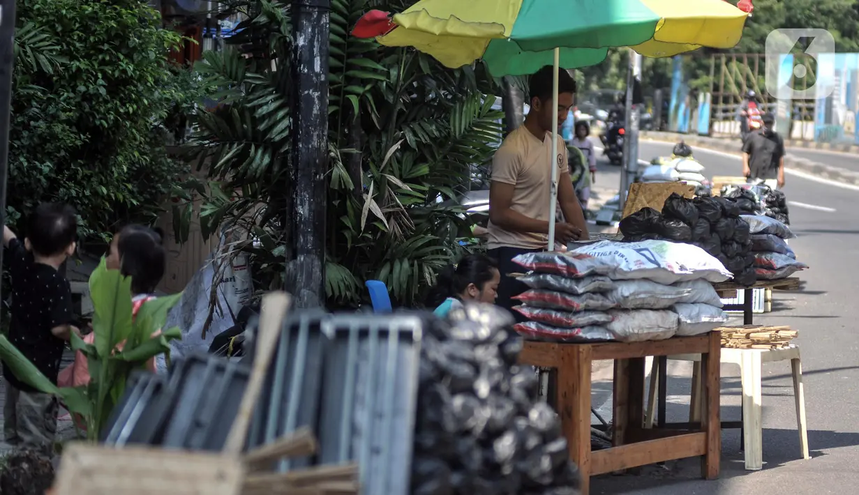 Pedagang arang menunggu pembeli di kawasan Manggarai, Jakarta Selatan, Minggu (10/7/2022). Perayaan Idul Adha membawa berkah tersendiri bagi para pedagang arang musiman di kawasan Manggarai karena banya warga membeli untuk tradisi membakar sate. (merdeka.com/Iqbal S. Nugroho)