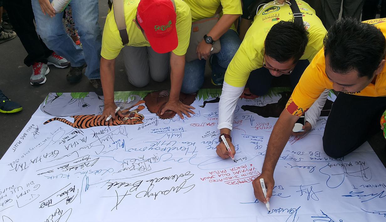 Peserta menandatangani Spanduk Deklarasi Keanekaragaman Hayati dibentangkan saat aksi jalan santai di kawasan Bundaran HI, Minggu (15/11/2015). Aksi ini untuk merayakan Hari Cinta Puspa dan Satwa Nasional 2015. (Media center AGP-AGN)