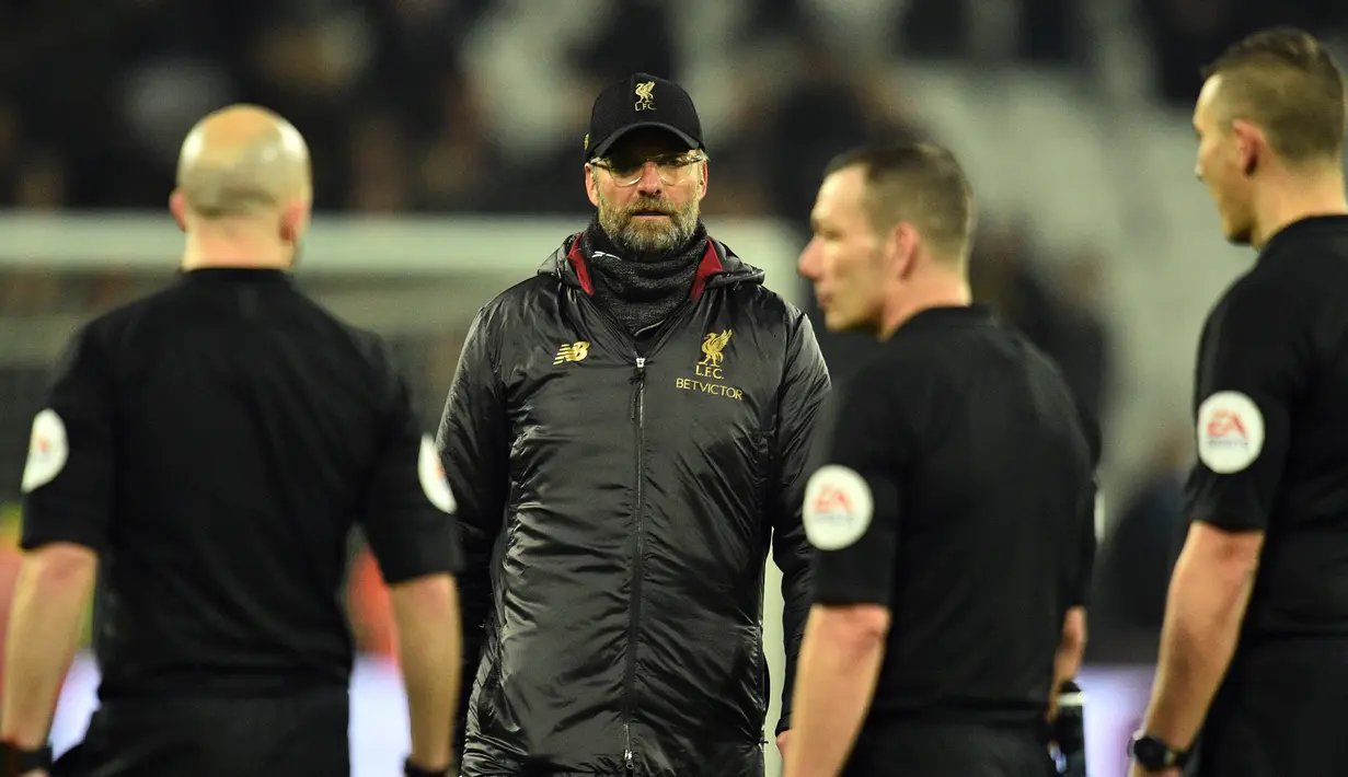 Pelatih Liverpool, Jurgen Klopp berjalan menghampiri para wasit usai pertandingan melawan West Ham United pada lanjutan Liga Inggris di The London Stadium (4/2). Liverpool bermain imbang 1-1 atas West Ham. (AFP Photo/Glyn Kirk)