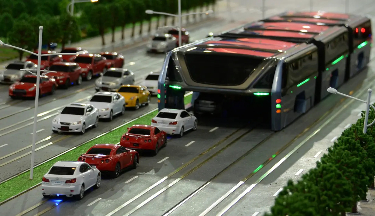 Sebuah model bus besar mengangkangi sejumlah mobil di sebuah pameran di Beijing, Cina, (20/5). Bus ini seperti terowongan yang lebarnya memakan dua jalur jalan, jadi saat melintas kesannya mengangkangi jalan. (REUTERS/Hu Qingming)