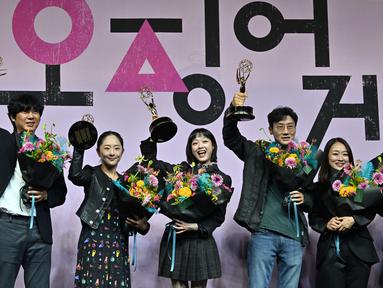 Aktris Korea Selatan Lee Yoo-mi dan Sutradara Hwang Dong-hyuk berpose dengan anggota staf serial Netflix "Squid Game" selama konferensi pers perayaan Emmy di Seoul, Korea Selatan (16/9/2022). Squid Game mencatat sejarah baru dengan menambah dua piala Emmy Awards 2022 sehingga totalnya menjadi enam. (AFP/Jung Yeon-je)