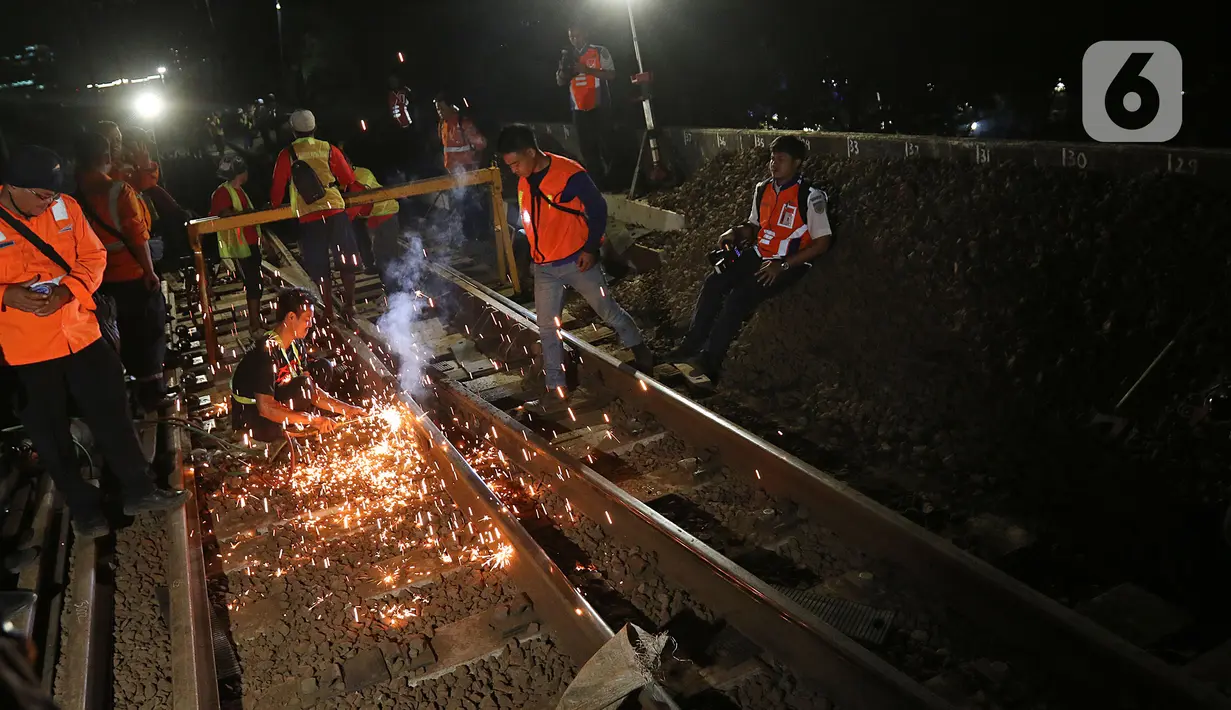 Sejumlah petugas merevitalisasi wesel rel di Stasiun KA Gambir, Jakarta, Kamis (14/2/2020) malam. PT KCI dan PT KAI Daop 1 Jakarta mengganti wesel rel di Stasiun Gambir dan Stasiun Jakarta Kota secara paralel yang akan berlangsung pada 13-23 Februari 2020. (Liputan6.com/Herman Zakharia)