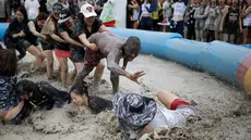 Sejumlah turis mengikuti sebuah permainan dalam Festival lumpur Boryeong di pantai Daecheon, Boryeong, Korea Selatan, (15/7). Festival lumpur Boryeong selalu mengadakan berbagai perlombaan yang menggunakan arena berlumpur. ( REUTERS/Kim Hong-Ji)