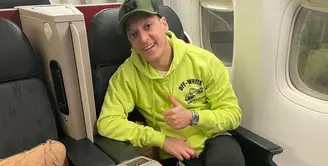 Mezut Ozil tiba di Indonesia hari ini. Kemarin, dirinya membagikan foto dirinya berpose di dalam pesawat mengenakan hoodie dari brand Off-White berwarna hijau terang. Ia padukan dengan celana jeans hitam dan cap hijau army. Foto: Instagram.