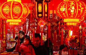 Orang-orang berbelanja dekorasi kemakmuran di sebuah stan untuk menyambut Tahun Baru Imlek, di sebuah Bazaar, Beijing, China, Minggu 1 Februari 2026. (AP Photo/Andy Wong)