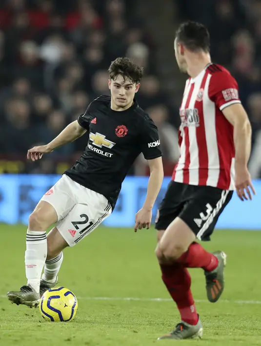 Gelandang Manchester United, Daniel James menggiring bola dari kawalan bek Sheffield United, Enda Stevens pada pertandingan lanjutan Liga Inggris di Stadion Bramall Lane (24/11/2019). MU bermain imbang 3-3 atas Sheffield Unite. (AP Photo/Jon Super)