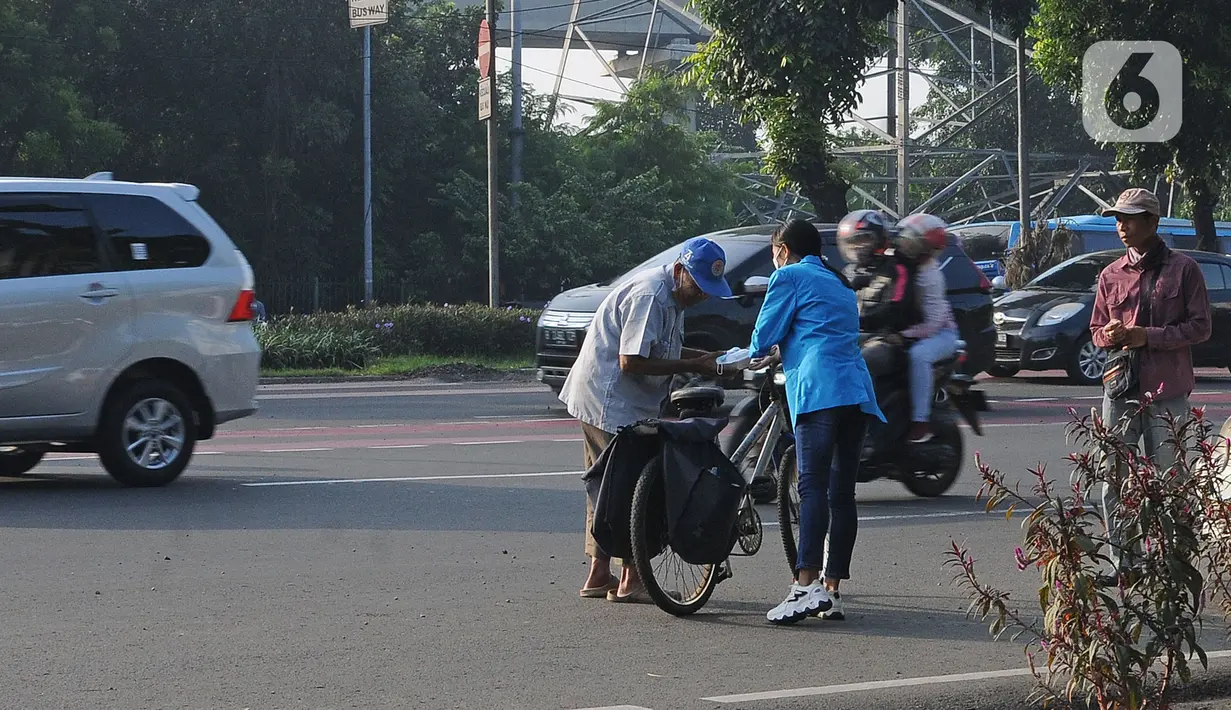 Mahasiswa memberikan makanan gratis kepada masyarakat di Universitas Kristen Indonesia (UKI), Cawang, Jakarta, Selasa (16/3/2021). Kegiatan berbagi makanan gratis yang dilakukan oleh civitas akademi UKI itu diselenggarakan selama tiga bulan. (Liputan6.com/Herman Zakharia)