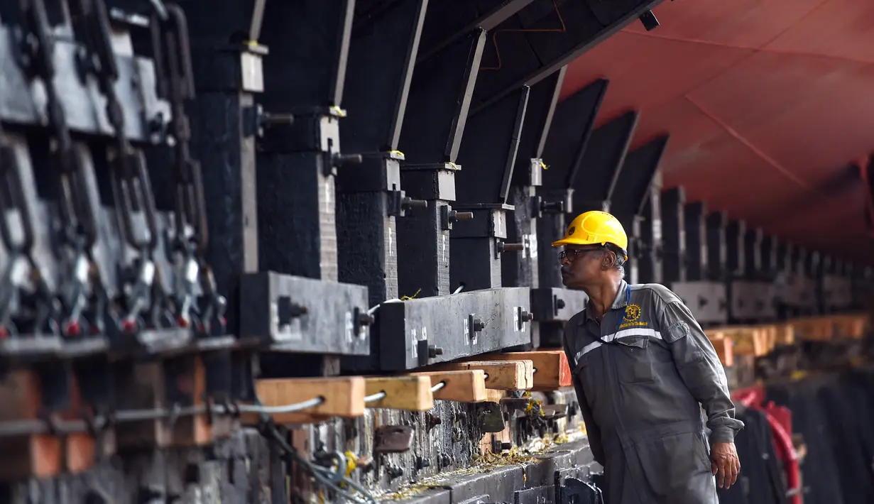 Seorang pekerja memeriksa persiapan akhir menjelang upacara peluncuran kapal perang INS Udaygiri di halaman Mazagaon Dock Shipbuilders Limited, Mumbai, India, Selasa (17/5/2022). (Punit PARANJPE/AFP)