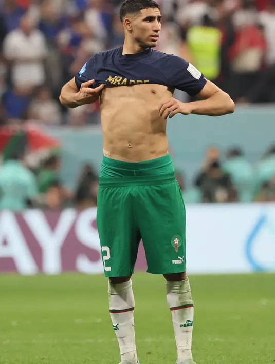 Bek Maroko Achraf Hakimi mengenakan jersey Prancis usai bertukar dengan Kylian Mbappe usai pertandingan semifinal Piala Dunia 2022 di Stadion Al-Bayt di Al Khor, Doha, Kamis (15/12/2022). Maroko gagal melaju ke final Piala Dunia 2022 Qatar setelah kalah dari Prancis dengan skor 2-0. (AFP/Karim Jaafar)