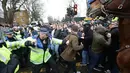 Suasana bentrokan suporter Millwall dengan petugas kepolisian sebelum pertandingan perempat final Piala FA antara Tottenham Hotspur melawan Millwall di White Hart Lane, London, (12/3). (Yui Mok//PA via AP)