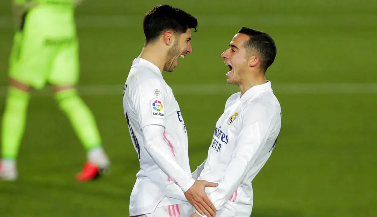 Gelandang Real Madrid, Marco Asensio, melakukan selebrasi bersama Lucas Vazquez usai mencetak gol ke gawang Celta Vigo pada laga Liga Spanyol di Stadion Alfredo Di Stefano, Sabtu (2/1/2021). Real Madrid menang dengan skor 2-0. (AP/Manu Fernandez)