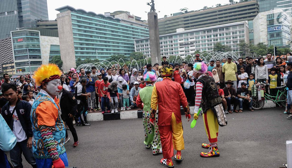 Aksi badut yang tergabung dalam Aku Badut Indonesia menghibur masyarakat saat car free day di Bunderan HI, Jakarta, Minggu (9/12). Aksi tersebut bentuk kampanye positif bertujuan mengajak masyarakat peduli terhadap sesama. (Liputan6.com/Faizal Fanani)