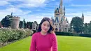 Main ke Tokyo Disneyland, Natasha Wilona tampil manis mengenakan sweatshirt pink fuschia dipadu high waisted pants bermotif.