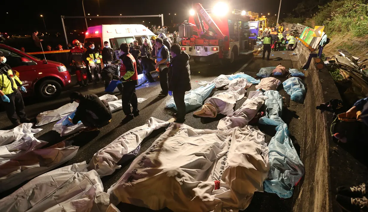 Sejumlah jasad penumpang yang tewas akibat bus wisata yang mereka tumpangi terbalik di ruas jalan dekat Taipe, ibu kota Taiwan, Selasa (14/2). Para penumpang berusia antara 20 hingga 60 tahun, namun sebagian besar adalah turis berusia lanjut. (AP Photo)