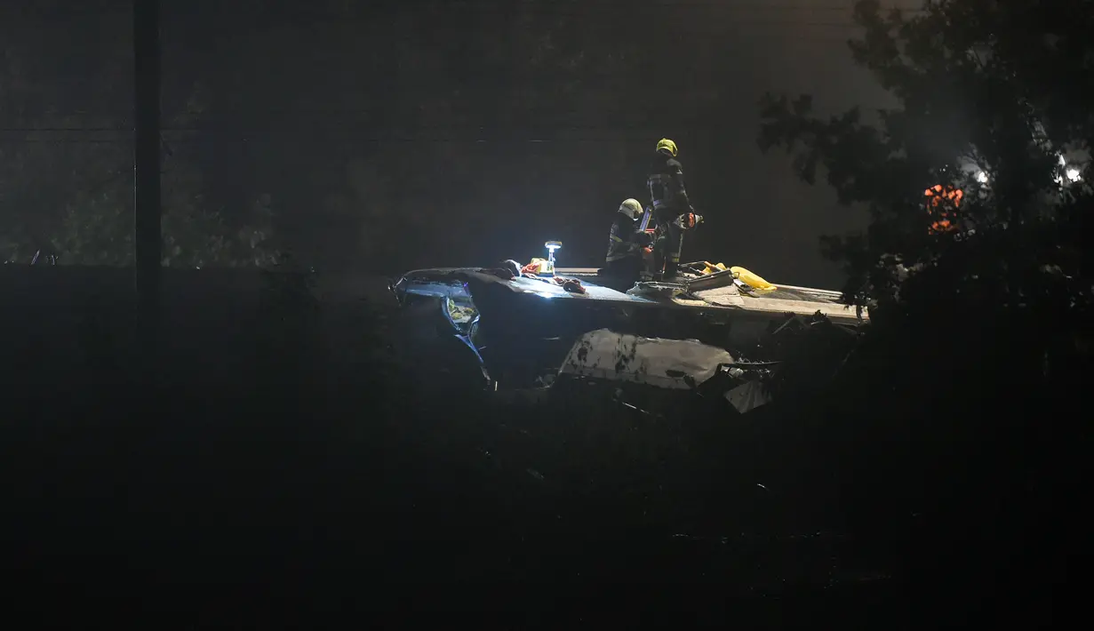 Petugas keselamatan darurat berada di lokasi tabrakan dua kereta di Kota Hermalle-sous-Huy, Belgia, Minggu (5/6). Kereta yang tengah membawa 40 penumpang itu menabrak gerbong belakang kereta barang yang juga berada di rel yang sama. (JOHN Thys/AFP)