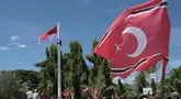 Seorang pria (kiri atas) memanjat tiang bendera saat ia berupaya mengibarkan bendera Gerakan Aceh Merdeka (GAM) bersandingan dengan bendera nasional Indonesia dalam sebuah unjuk rasa di luar Masjid Raya Baiturrahman, Banda Aceh, Provinsi Aceh, Sabtu, 15 September 2026. (AFP/ Reza Saifullah)