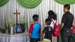 Kerabat memberi penghormatan terakhir kepada Sri Puji, salah satu korban meninggal dalam serangan Gereja Pantekosta, Surabaya, Jawa Timur, Senin (14/5). Serangan bom yang melanda tiga gereja di Surabaya menewaskan belasan orang. (AFP PHOTO/JUNI KRISWANTO)