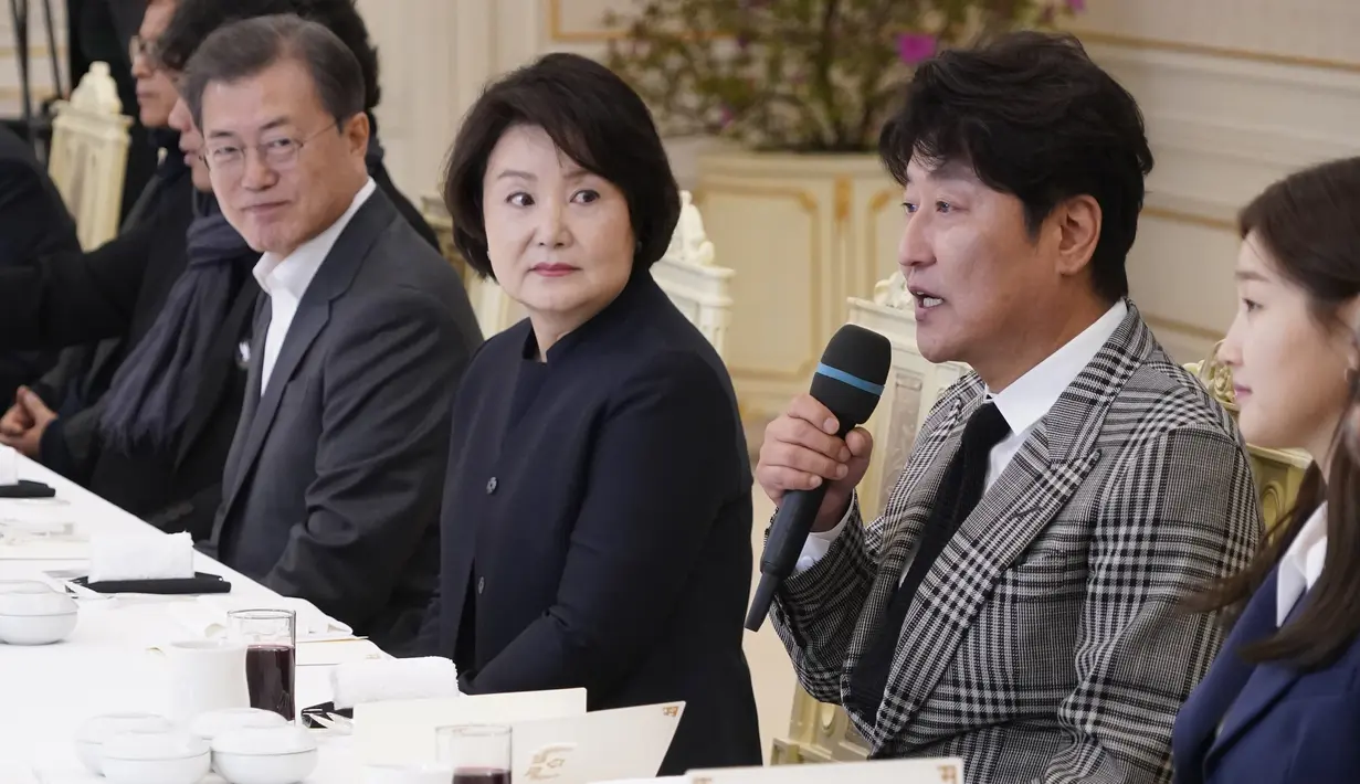 Aktor film Parasite Song Kang-ho berbicara di sebelah Presiden Korea Selatan Moon Jae-in dan Ibu Negara Kim Jung-sook saat makan siang di Blue House, Kamis (20/2/2020). Presiden Moon mengundang Sutradara Bong Joon Ho dan seluruh tim untuk merayakan kemenangan Parasite di Oscar 2020 (KIM HONG-JI/AFP)