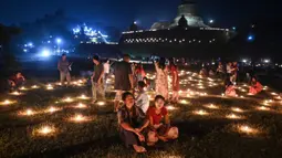 Orang-orang mengambil bagian dalam Festival Tazaungdaing di pagoda di Mrauk U, Rakhine, Myanmar, 18 November 2021. Tazaungdaing adalah Festival Bulan Purnama yang diadakan setiap tahun pada bulan purnama, bulan kedelapan dalam kalender Burma. (STR/AFP)