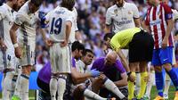 Bek Real Madrid, Pepe (tengah) menjalani pemeriksaan di tengah laga kontra Atletico Madrid, Sabtu (8/4/2017) malam WIB, di Stadion Santiago Bernabeu. Pepe mendapat cedera dan dilarikan ke rumah sakit.  (AFP/Pierre-Philippe Marcou)