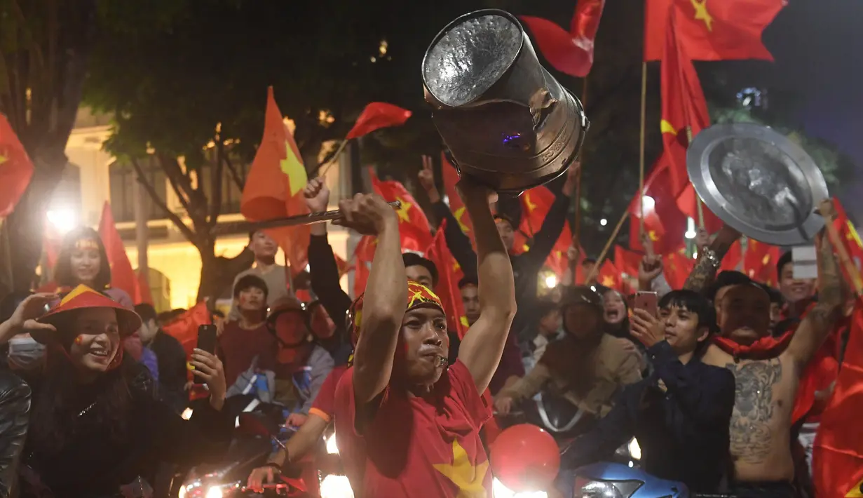 Sejumlah warga konvoi merayakan keberhasilan Vietnam mengalahkan Qatar pada semifinal Piala AFC U-23 di Hanoi, Rabu (23/1/2018). Vietnam berhasil lolos ke final untuk menantang pemenang antara Uzbekistan dan Korea Selatan. (AFP/Hoang Dinh Nam)