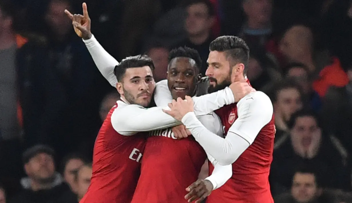 Pemain Arsenal merayakan gol Danny Welbeck (tengah) ke gawang West Ham United pada laga perempat final Piala Liga Inggris di Emirates Stadium, Selasa (20/12). Gol tunggal Welbeck memberikan Arsenal kemenangan 1-0 atas West Ham. (Ben STANSALL/AFP)