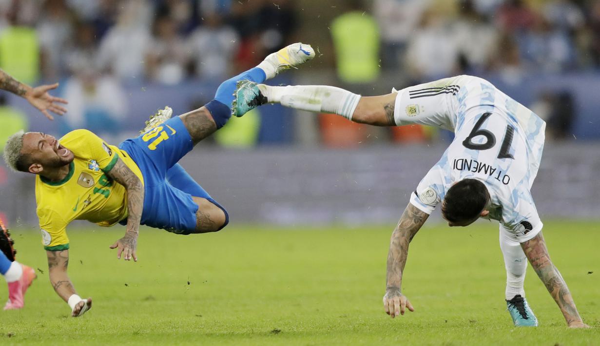 Striker Brasil, Neymar, terjatuh saat berebut bola dengan bek Argentina, Nicolas Otamendi, pada laga final Copa America 2021 di Stadion Maracana, Rio de Janeiro, Brasil, Minggu (11/7/2021). (Foto: AP/Silvia Izquierdo)
