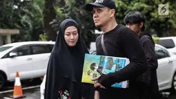 Lyra Virna dan suaminya Fadlan saat tiba di Ditreskrimsus Polda Metro Jaya, Jakarta, Kamis (22/3). Lyra datang untuk memenuhi panggilan terkait statusnya sebagai tersangka kasus dugaan pencemaran nama baik sebuah travel umrah. (Liputan6.com/Faizal Fanani)