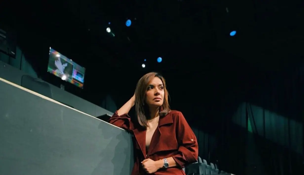 Long coat berwarna merah serta celana tartan berwarna navy dan merah adalah outfit yang sangat ciamik. (instagram/najwashihab)