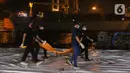 Tim DVI Polri membawa kantong jenazah yang diduga berisi bagian tubuh penumpang pesawat Sriwijaya Air SJ 182 di Dermaga JICT 2, Jakarta, Minggu (10/1/2021) dini hari. Sriwijaya Air SJ 182 membawa 62 penumpang dan kru. (Liputan6.com/Helmi Fithriansyah)