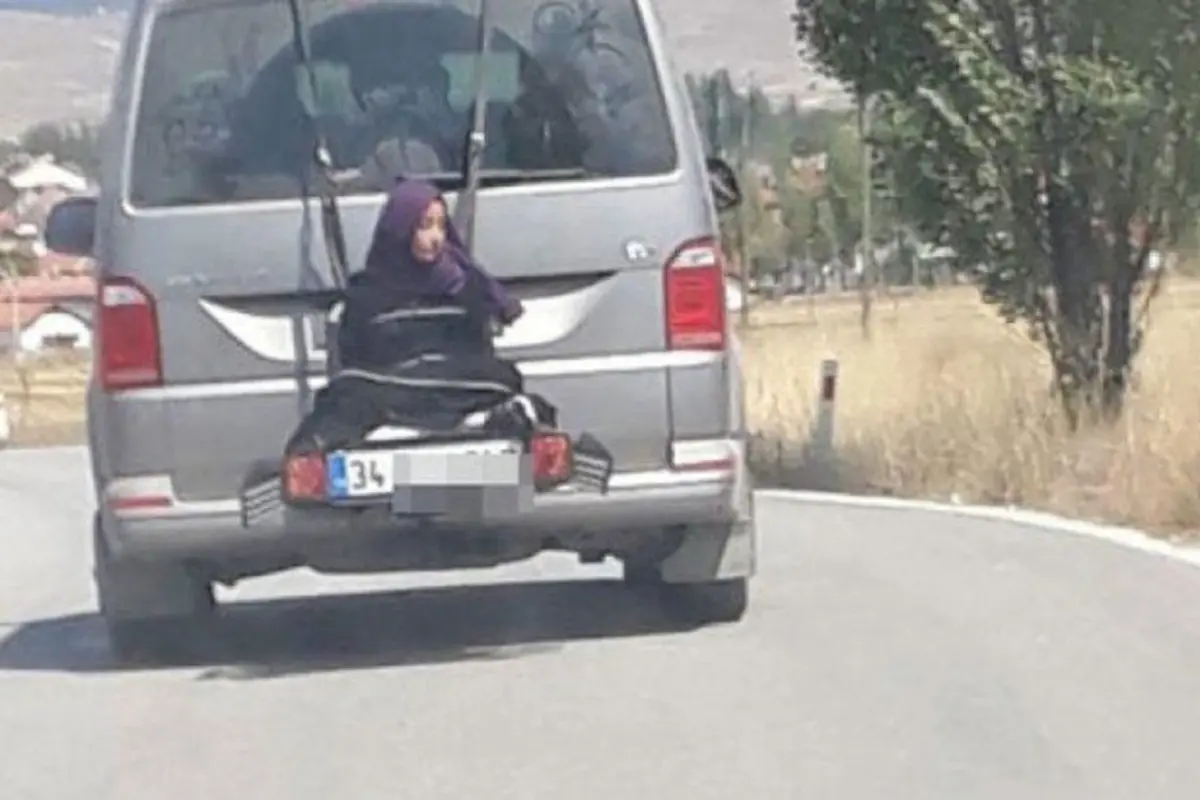 Pengendara mobil mengikat gadis kecil dibelakang.